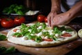 Preparation of classic Italian pizza with homemade tomato sauce, basil and mozzarella