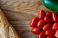 Preparation of colorful vegetables tomatoes, bagette, courgettes on cutting board