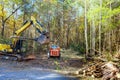 In preparation for constructing a new home builder uproots trees from forest with tractor