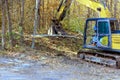 In preparation for construction builder uses a tractor to uproot trees at forest