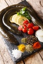 Preparation for cooking raw eel with spices, vegetables and lemon close up on a slate board. vertical Royalty Free Stock Photo