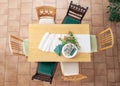 Preparation for dinner with table runner, white plates, cutlery, green napkins and some tulip flowers, six different wooden chairs Royalty Free Stock Photo