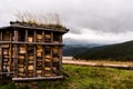 Preparation of firewood for the inhabitants of the mountains. Beautiful wood shed. Barn on the background of the forest