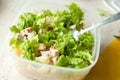 Preparation of hawaiian salad. Chopped ruddy chicken breasts with leaf salad, pieces of pineapple and crushed walnut.