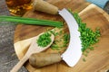 Preparation of herbs for meal:  brown wood cutting board with chefÃÂ´s mincing knife, chopped green chives and wooden spoon Royalty Free Stock Photo