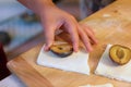 Preparation of homemade fruit dumplings with plums. Czech specialty of sweet good food. Dough on kitchen wooden table with hands Royalty Free Stock Photo