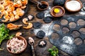 Preparation of Italian black ravioli with seafood shrimps and crabs on black plate, gray stone slate background. Top