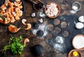 Preparation of Italian black ravioli with seafood shrimps and crabs on black plate, gray stone slate background. Top