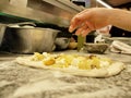 Preparation of an Italian pizza, with potatoes and mozzarella