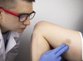 The vascular surgeon examines the outer thigh where the varicose veins are present. Preparation for laser treatment and