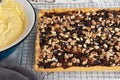 Preparation for making a cake. Shortbread pie with jam and walnuts on cooling rack. Home made custard cream for cake