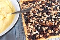 Preparation for making a cake. Shortbread pie with jam and walnuts on cooling rack. Home made custard cream for cake