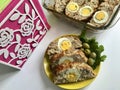 Preparation of minced meat rolls. As a stuffing boiled egg. Slices of the finished roll are on a plate with olives and greens. Royalty Free Stock Photo