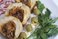 Preparation of minced meat rolls. As a stuffing boiled egg. Slices of the finished roll are on a plate with olives and greens. Royalty Free Stock Photo