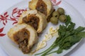 Preparation of minced meat rolls. As a stuffing boiled egg. Slices of the finished roll are on a plate with olives and greens. Royalty Free Stock Photo