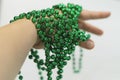 Preparation for new year`s holidays. Decoration on the hands. Beautiful new year green beads on a woman`s hand. Christmas necklace