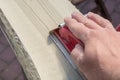 Preparation of an old wooden board by grinding with a hand sanding block