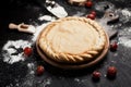 Preparation for pizza, flour and tomatoes on a round wooden board on a black wooden table