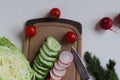 Preparation of a salad of radishes, cucumbers and cabbage. Royalty Free Stock Photo