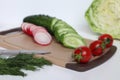 Preparation of a salad of radishes, cucumbers and cabbage. Royalty Free Stock Photo