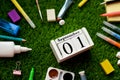 Preparation for school in the summer, school supplies on the grass and a calendar from September 1