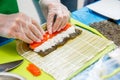 Preparation of sushi roll in restaurant, close up on chef hands
