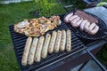 Preparation of tasty sausages and meat on the gil.