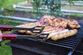 Preparation of tasty sausages and meat on the gil.