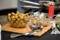 preparation of traditional spanish tapas served on plates on black table background. Patatas Bravas with Gambas Ajillo