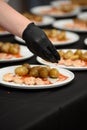 preparation of traditional spanish tapas served on plates on black table background. Patatas Bravas with Gambas Ajillo