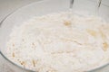 Preparation of the yeast dough. Adding water to the dough in the glass bowl Royalty Free Stock Photo