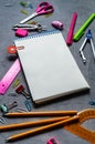 Preparations for school: A large white notepad, pencils, a pink ruler, scissors and other consular accessories on a gray