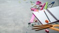 Preparations for school: A large white notepad, pencils, a pink ruler, scissors and other consular accessories on a gray