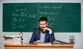 Prepare for lesson. Teacher strict serious bearded man chalkboard background. Teacher reading book. Rules of school