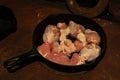 Prepare meat in a cast-iron frying pan standing on a rusty wood-burning stove