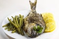 Prepared, cooked, fried, baked dorado fish or sea bream with green beans and lemon slices