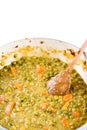 Prepared cooked green peas with carrot and wooden spoon