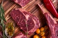 Assorted minced meat ingredients - rack of calf, ribeye, rack of lamb, with garlic, onions, red and yellow tomatoes, red pepper Royalty Free Stock Photo