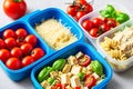 Prepared diet Lunches in lunch boxes: pasta, parmesan, lettuce, cherry tomatoes with basil.