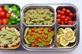 Prepared diet Lunches in lunch boxes: pasta, parmesan, lettuce, cherry tomatoes with basil.