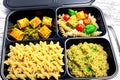 Prepared diet Lunches in lunch boxes: pasta, parmesan, lettuce, cherry tomatoes with basil.