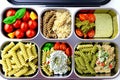 Prepared diet Lunches in lunch boxes: pasta, parmesan, lettuce, cherry tomatoes with basil.