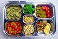 Prepared diet Lunches in lunch boxes: pasta, parmesan, lettuce, cherry tomatoes with basil.