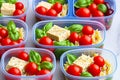 Prepared diet Lunches in lunch boxes: pasta, parmesan, lettuce, cherry tomatoes with basil.