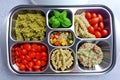 Prepared diet Lunches in lunch boxes: pasta, parmesan, lettuce, cherry tomatoes with basil.