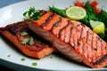 Prepared grilled salmon fish dish with vegetables on plate closeup. Royalty Free Stock Photo