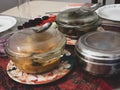Prepared Indian food dishes in containers on a dining table at an Indian home.
