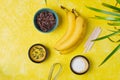 Prepared ingredients for cooking frozen chocolate covered bananas on a yellow concrete background. No-bake desserts