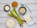 Prepared ingredients for cooking rhubarb crumble on a light wooden background. Rhubarb recipes