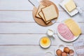 Prepared ingredients for making a hot croque madame sandwich on a white wooden background. Recipes for sandwiches, hot breakfasts